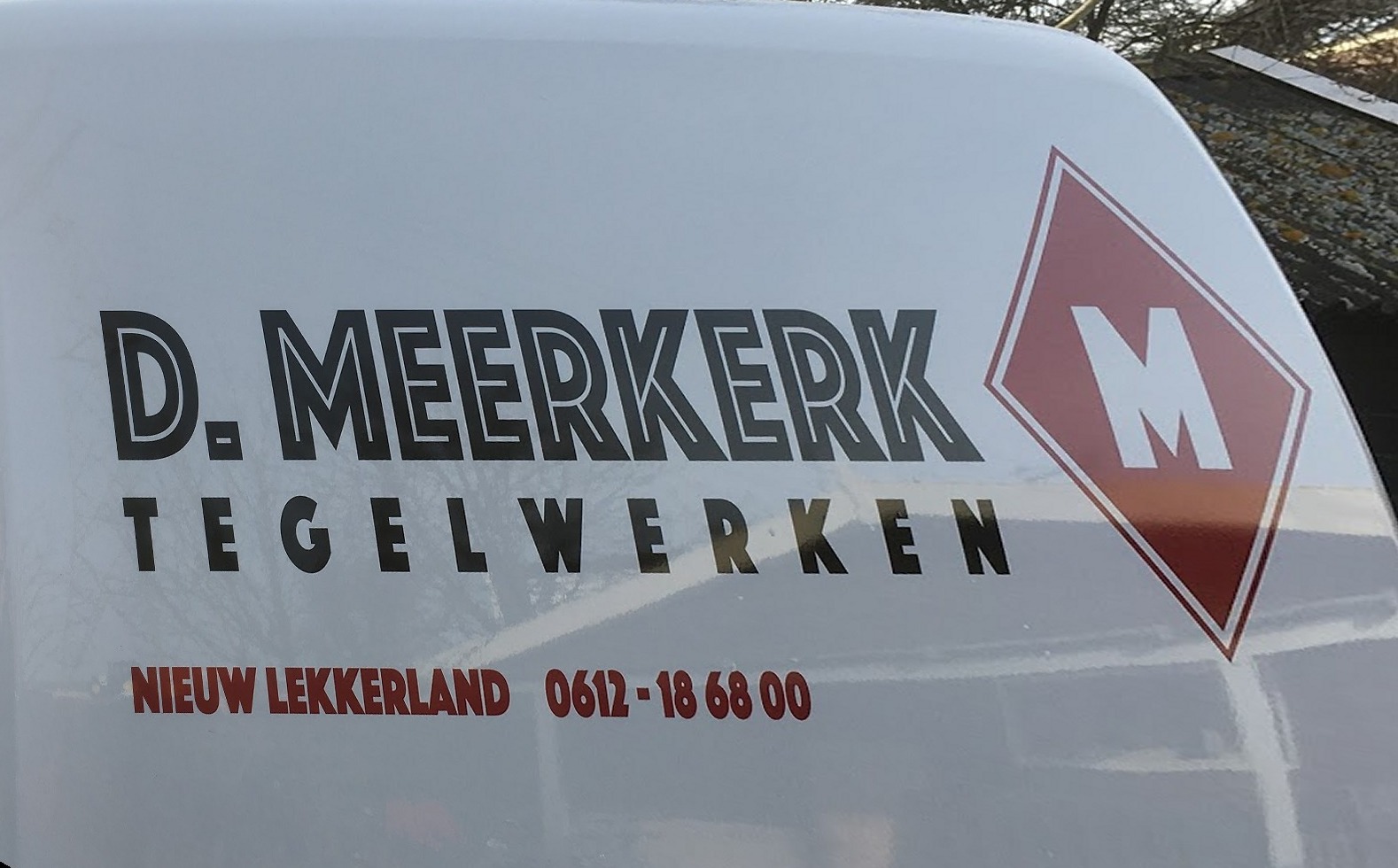 Bedrijfsbus met de belettering D. Meerkerk Tegelwerken, Nieuw Lekkerland, en het rode ruitlogo met M